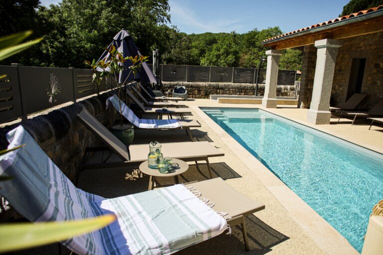 Transats et serviettes au bord de la piscine — Hôtel La Garenne, Labeaume (Ardèche)