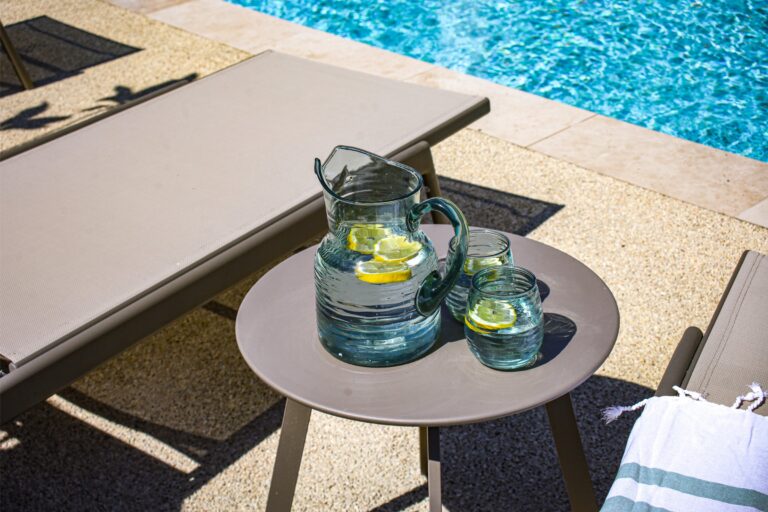 Carafe d'eau citronnée sur une table au bord de la piscine — Hôtel La Garenne, Labeaume (Ardèche)