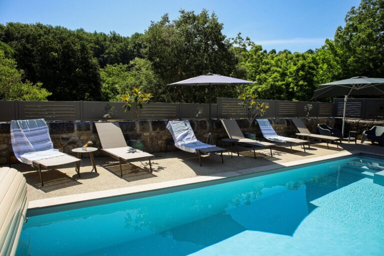 Transats et parasol au bord de la piscine — Hôtel La Garenne, Labeaume (Ardèche)